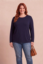 Haut Narcisse marine porté par notre mannequin rousse avec un sac cognac sur fond beige rosé – mode grande taille femme
