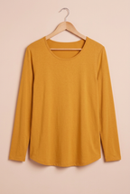 Haut Narcisse moutarde présenté de face sur cintre sur fond beige rosé – mode grande taille femme